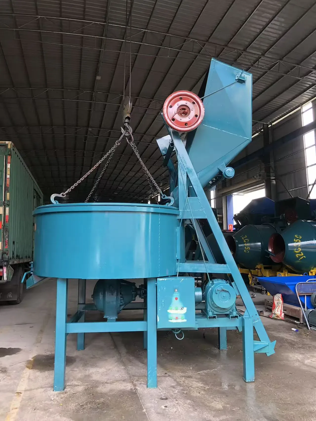 Flat-mouth concrete mixer, used to display equipment and structures related to hopper-feeding concrete mixing equipment.
