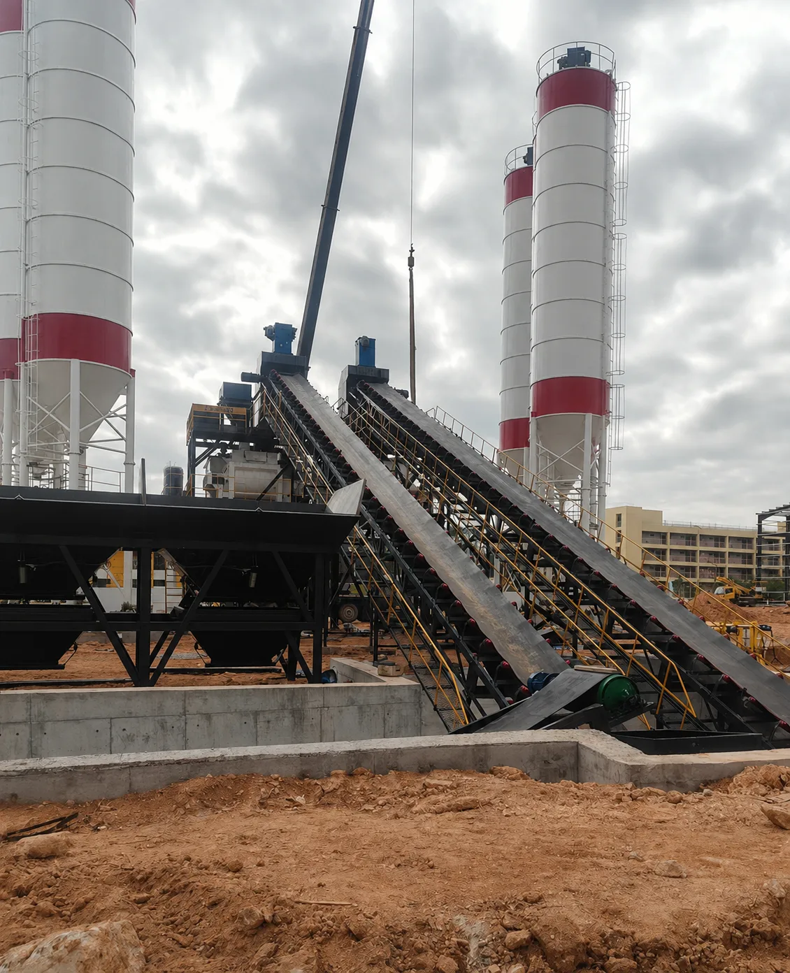Real shot of ready-mix concrete batching plant twin-line equipment installation and inclined conveying system